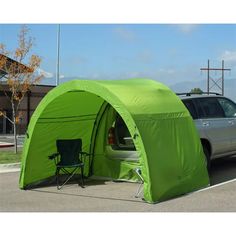 a car is parked in front of a green tent