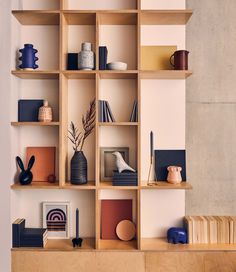 a shelf with books, vases and other items on it