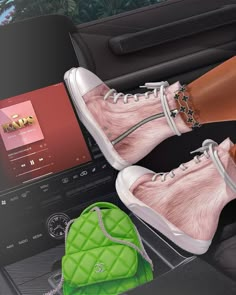 a woman's feet in pink and white shoes next to a green handbag