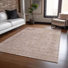 a living room filled with furniture and a large rug on top of a hard wood floor