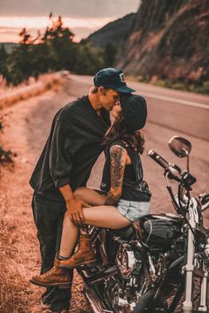 a man kissing a woman on the back of a motorcycle