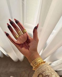 a woman's hand with hendix and gold rings on her left hand