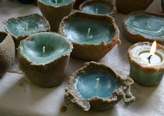 several tea lights sitting on top of a white cloth covered table next to each other