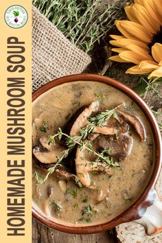 a bowl filled with mushroom soup next to a sunflower and some bread on the side