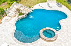 an aerial view of a swimming pool surrounded by landscaping