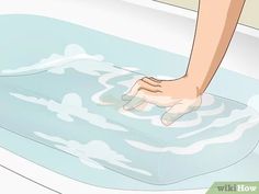 a person washing their feet in a bathtub with soap on the floor and water running down it