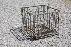 a metal cage sitting on top of gravel