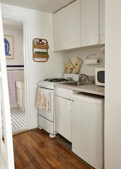 a kitchen with white appliances and wooden floors