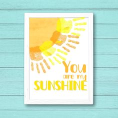 the words you are my sunshine on a white frame against a blue wooden background with an orange and yellow sun