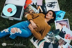 a woman laying on the ground surrounded by various records and cds, with her arms crossed