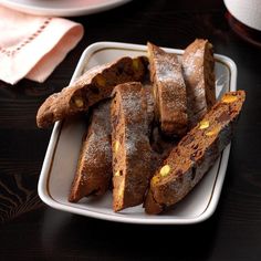 several pieces of bread on a plate with powdered sugar