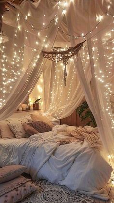 a bed with white sheets and lights hanging from it's canopy over the headboard