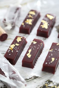 several pieces of chocolate with gold flakes on them