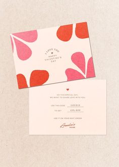 two wedding cards with red and pink hearts on them, one is folded in white paper