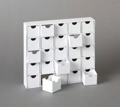 several white boxes stacked on top of each other with black heart shaped holes in them