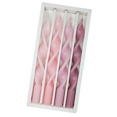 four pink candles in a white box on a white background