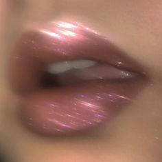 a woman's lips with shiny pink lipstick on top and bottom half of her face