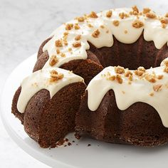 a bundt cake with white frosting and sprinkles sitting on a plate