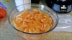 an orange is in a glass bowl on the counter next to a crockpot