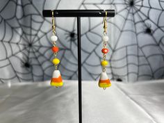 a pair of earrings with colorful beads hanging from it's earwires on a stand