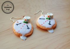 two decorated cookies sitting on top of a wooden table