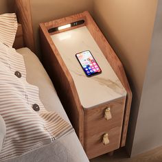 a bed with a wooden night stand next to a phone on top of the nightstand