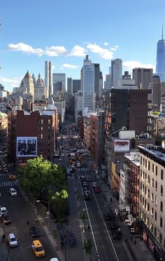 a city street filled with lots of traffic next to tall buildings and tall skyscrapers