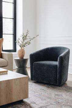 a living room filled with furniture and a vase on top of a wooden coffee table