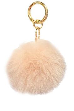 a pom - pom keychain hanging from a gold chain on a white background