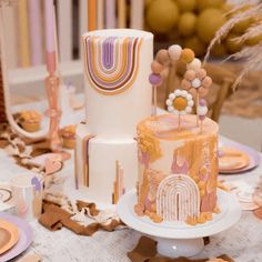 a table topped with three tiered cakes covered in frosting and colorful toppings