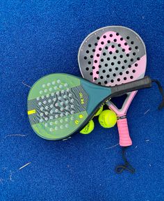 two tennis racquets and a racket on a blue carpeted floor