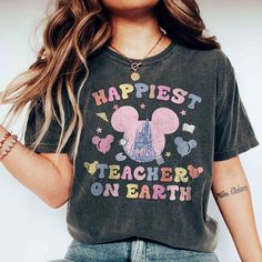 a woman wearing a mickey mouse shirt with the words happest teacher on earth