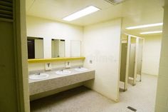 an empty public restroom with three sinks and two urinals on the wall stock photos