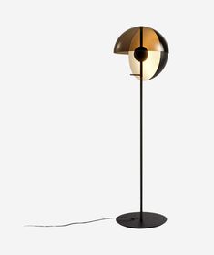 a lamp that is on top of a white surface with a black base and a light bulb