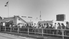 a group of people standing next to each other on a bridge