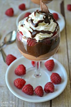 two desserts with raspberries and whipped cream on them