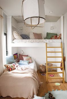 a loft bed with a ladder in the middle and pillows on the bottom bunk below