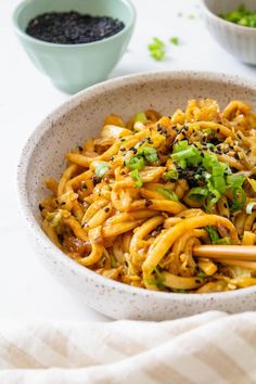 a white bowl filled with noodles and vegetables