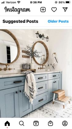 a bathroom with blue cabinets and two round mirrors above the sink is featured on instagram