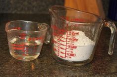 two measuring cups with flour in them sitting on a counter next to a measuring cup