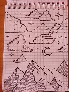 a notebook with a drawing of mountains, clouds and stars in the sky on it