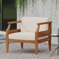 a wooden chair sitting on top of a brick floor next to a table and plant