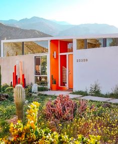 an orange and white house with mountains in the background