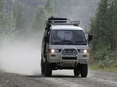 a white truck driving down a dirt road