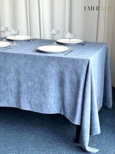 a blue table cloth with white plates on it