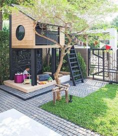 a small house with a tree in the front yard and stairs leading up to it