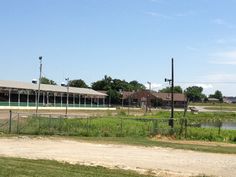 an empty parking lot next to a large building and some grass in front of it