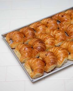 there are many croissants on the tray