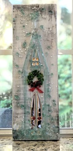 a house made out of glass with a wreath on the top and two knives in front