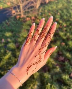 a woman's hand with henna tattoos on it